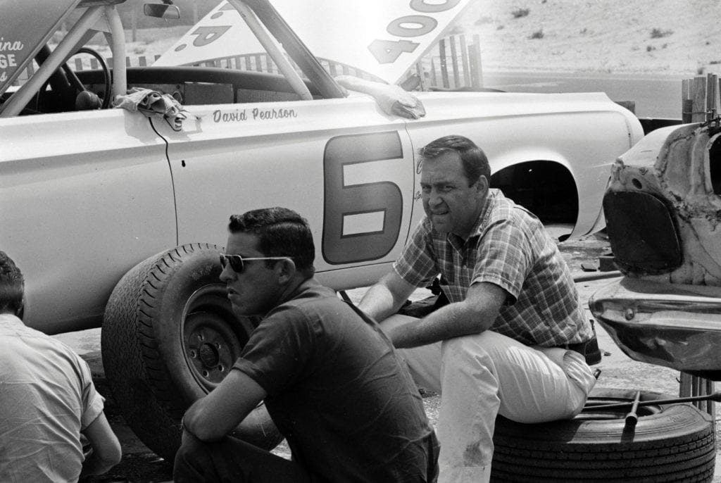 David Pearson (in sunglasses) seated by his number 6 Dodge. The man to his right is journalist Brock Yates.
